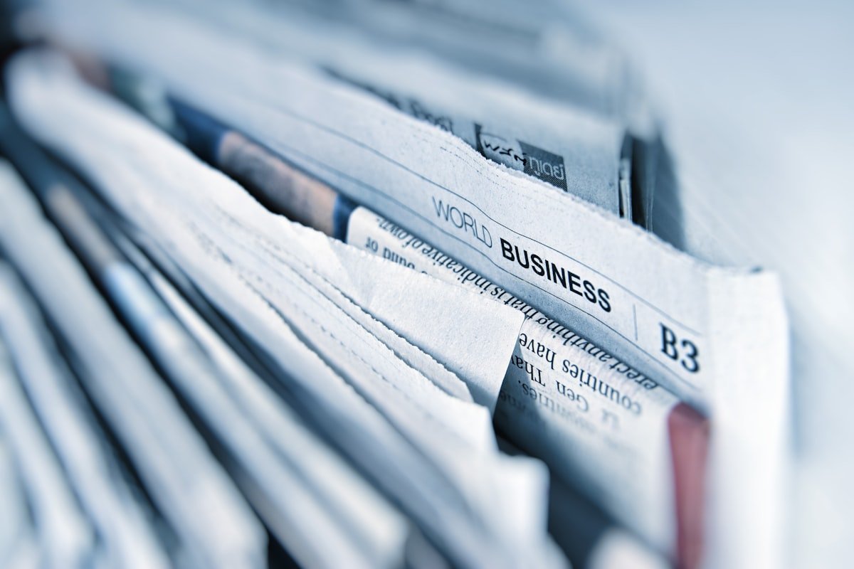 Stack of rolled business newspapers representing corporate reputation and trust in commerce