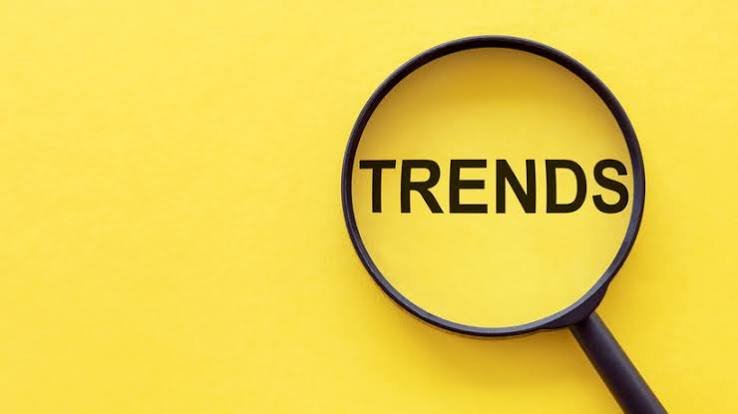 Magnifying glass over the word trends on a yellow background representing spotting emerging trends
