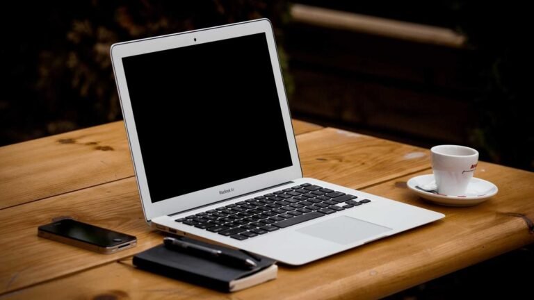 Open laptop on a wooden desk representing dependable everyday technology tools