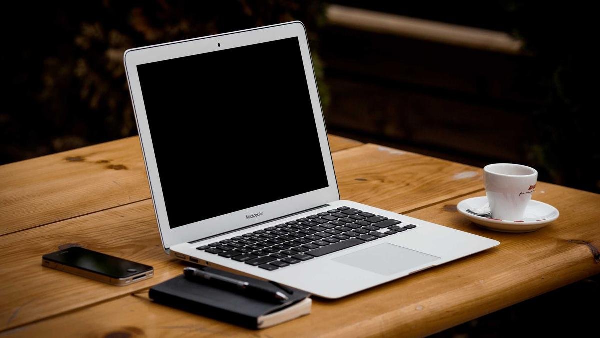 Open laptop on a wooden desk representing dependable everyday technology tools